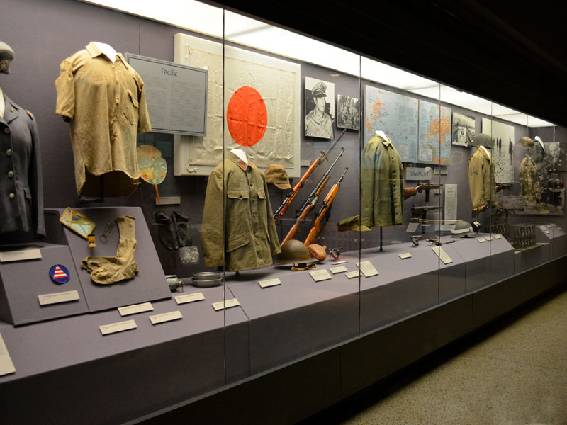 Museum artifacts inside a glass enclosure along a wall at the West Point Museum.